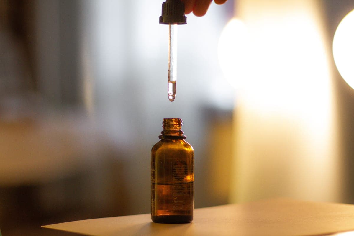 Serum dropper bottles arranged on a dark surface with directional lighting