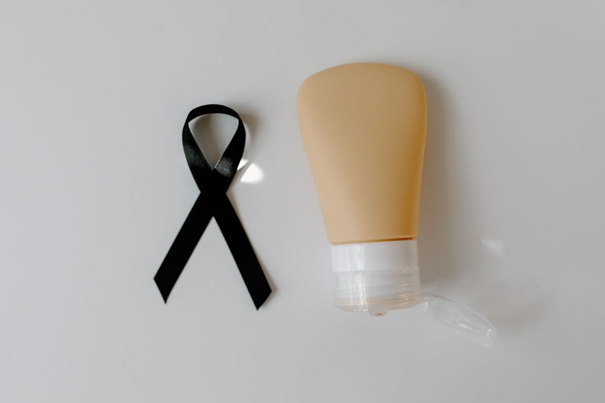 Two sunscreen tubes side by side on dark stone